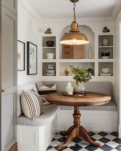 a kitchen with a table and bench in the corner, surrounded by built - in shelves