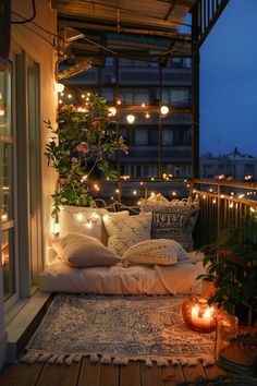 a balcony with lights and pillows on the floor next to potted plants in pots