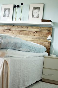 an image of a bed made out of wood with pictures on the wall above it