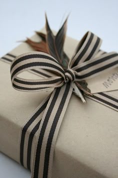 a gift wrapped in brown and black ribbon