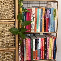 a bookshelf filled with lots of books next to a plant