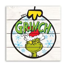 the grinch christmas ornament is hanging on a wood planks background with snowflakes