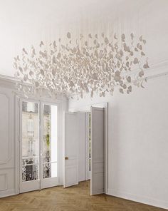 a chandelier hanging from the ceiling in an empty room with doors and windows