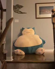 a large stuffed animal sitting on top of a stair case