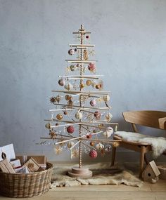 a wooden christmas tree sitting on top of a rug next to a chair and table