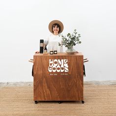 a woman in a hat standing behind a wooden counter