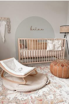 a baby's room with a crib, bed and ottoman in the middle