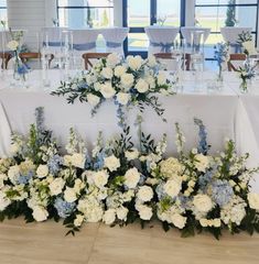 the table is set up with white and blue flowers