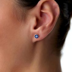 a close up of a person wearing earring with an evil eye design on it