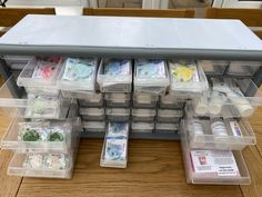 several plastic containers filled with money on top of a wooden table