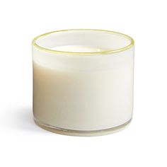 a white candle sitting on top of a table next to a glass container filled with liquid