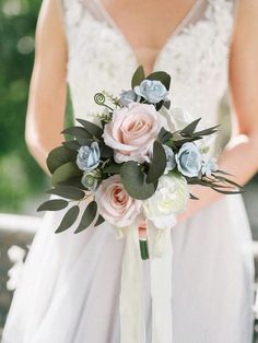 a bridal holding a bouquet of pink and blue flowers