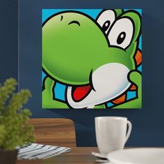 an image of a cartoon character on the wall above a table with a cup and saucer