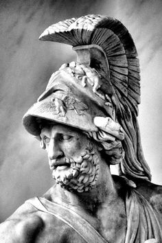 a black and white photo of a statue of a man wearing a helmet with feathers on his head