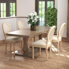 a wooden table with four chairs and a potted plant on top of the table