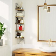 a bathroom sink sitting under a mirror next to a wooden counter