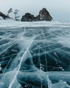 an ice covered lake with some rocks in the background