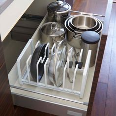 an organized kitchen drawer with pots and pans