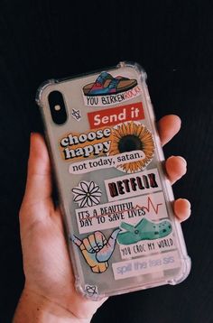 someone is holding their phone case with some stickers on it