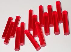 red plastic tubes are lined up on a white surface