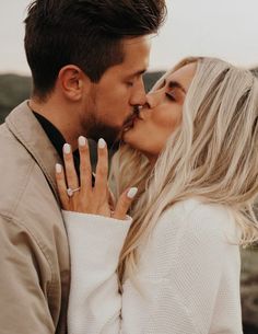 a man and woman smiling at each other with their wedding rings on their fingers,