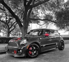 a black and white photo of a car parked in front of a tree