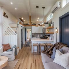 a living room filled with furniture next to a kitchen