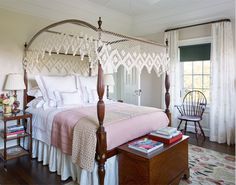 a bedroom with a four poster bed and pink comforter on it's cover