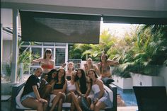 a group of women sitting next to each other in front of a pool