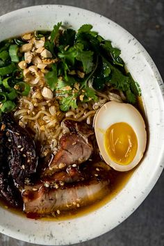 the best instant pot ramen recipe with beef, egg and greens in a white bowl