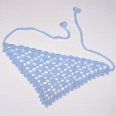 a blue crocheted triangle on a white surface