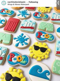 some decorated cookies are laying on a white table top with sunglasses, sunflowers and other items