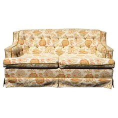 an old fashioned couch with floral fabric on the back and arms, sitting against a white background