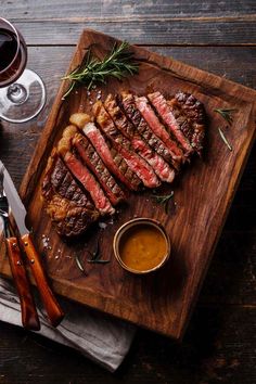 steak on a cutting board with sauces and utensils