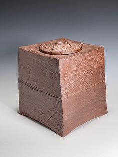 a small wooden box with a lid on it's side, in the shape of a cube