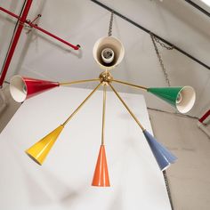 a chandelier with five different colored lights hanging from it's center point