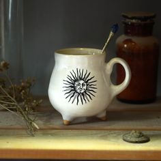 This handmade witches cauldron mug features a vintage picture of the sun from ancient manuscripts. Overglaze paint. ! MADE TO ORDER - Processing time 2-3 weeks ! The cauldron mug is handmade on a potter's wheel, and the handle and legs are hand-sculpted. This magic cauldron mug would make a great gift for that special person. Because each mug is individually and completely handmade, the one I'll post to you is going to be a little different in shape and final result of glaze, from the one in the photos. ! MADE TO ORDER - Processing time 2-3 weeks ! Each item is individually wheel thrown All our glazes are lead-free and food-safe. All our dishes are micro oven dishwasher safe Volume: 10 fl oz ( 250-300 ml ) Height: 4" (10 cm) Diameter: 4" (10 cm) Magic Cauldron, Cauldron Mug, Micro Oven, Ancient Manuscripts, Pictures Of The Sun, Mug Painting, Painting Pottery, The Cauldron, Image Vintage