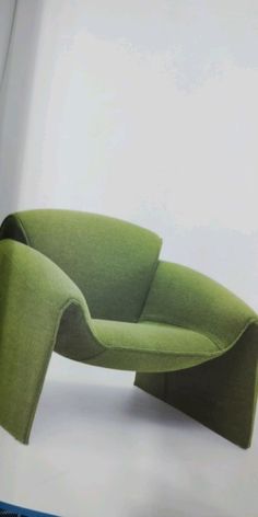 a green chair sitting on top of a white floor