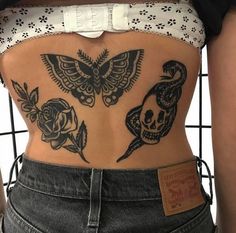 the back of a woman's stomach with skulls and roses on it