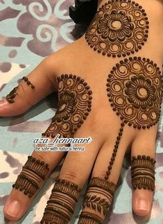 a woman's hand with henna tattoos on it