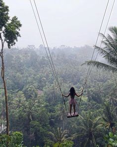 a woman on a zip line in the jungle