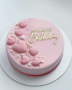 a birthday cake with pink frosting and hearts on it