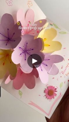 someone is holding up a flower pop up card