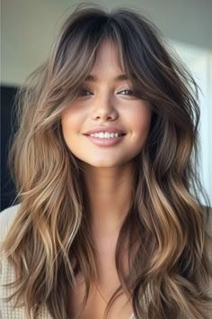 a woman with long, wavy hair is smiling