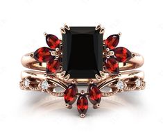 a black diamond ring with red stones on it