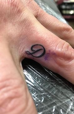 a person's hand with a small tattoo on their left thumb and the word love written in black ink