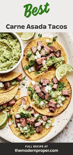 carne asada tacos topped with onion, cilantro and guacamole, served with lime wedges and a bowl of guacamole