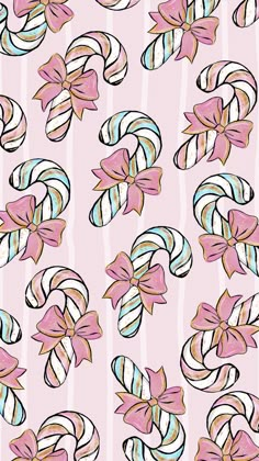 candy canes with bows and stripes on a pink background seamless wallpaper pattern