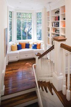 a window seat in the corner of a room with bookshelves on either side