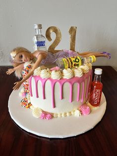 a birthday cake decorated with barbie dolls and confetti on the top is displayed